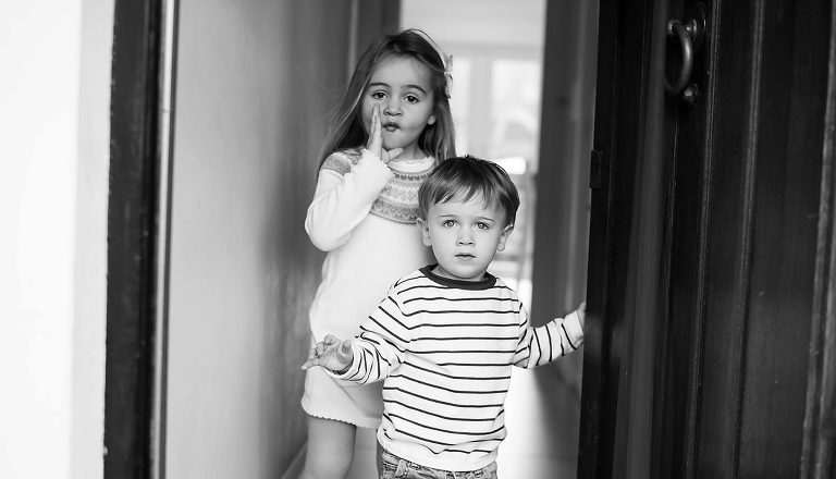 Brother and sister standing by door