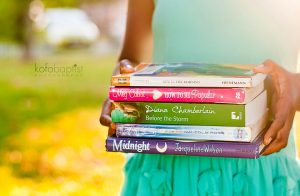 Young girl carrying a bunch of books.