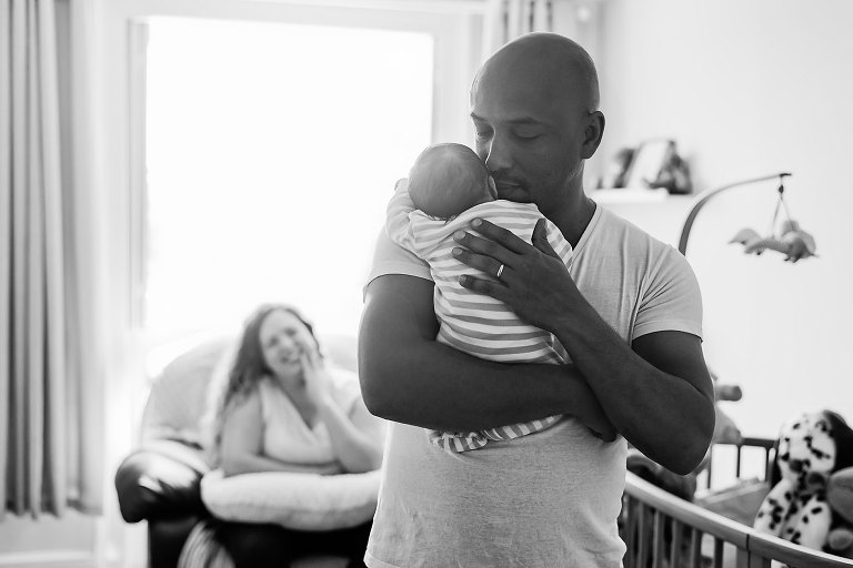 Baby sleeping on daddy's shoulders.