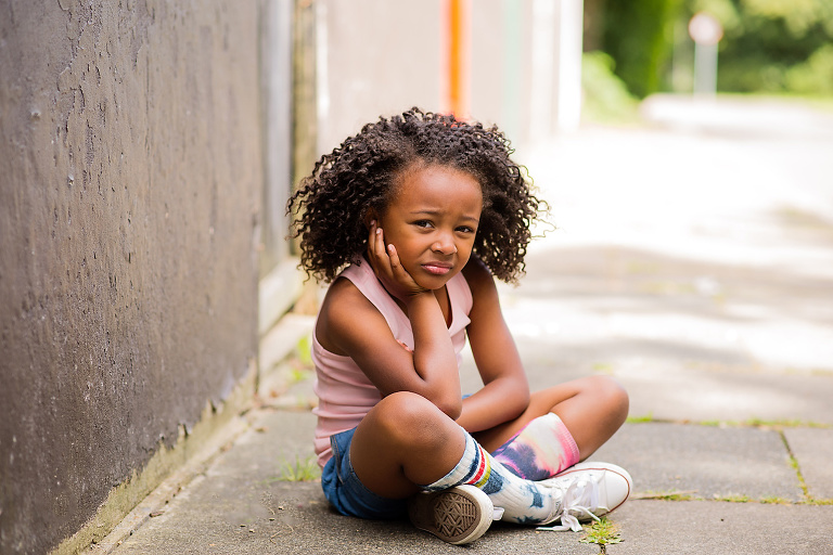Girl sitting on floor with hand under chin