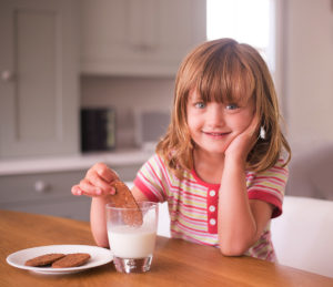 Girl drinking milk and eating cookies by Essex child photographer Kofo Baptist.