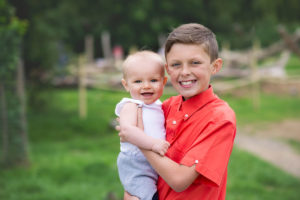 Portrait of big brother holding baby brother