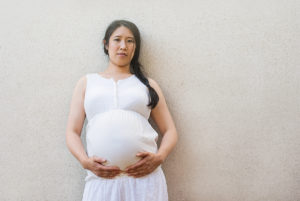 Pregnant woman with hands on bump. Outdoor Maternity Photo Session captured by maternity photographer Kofo Baptist