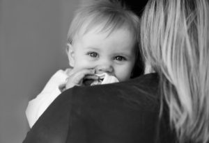 Mum carries baby on her shoulder.