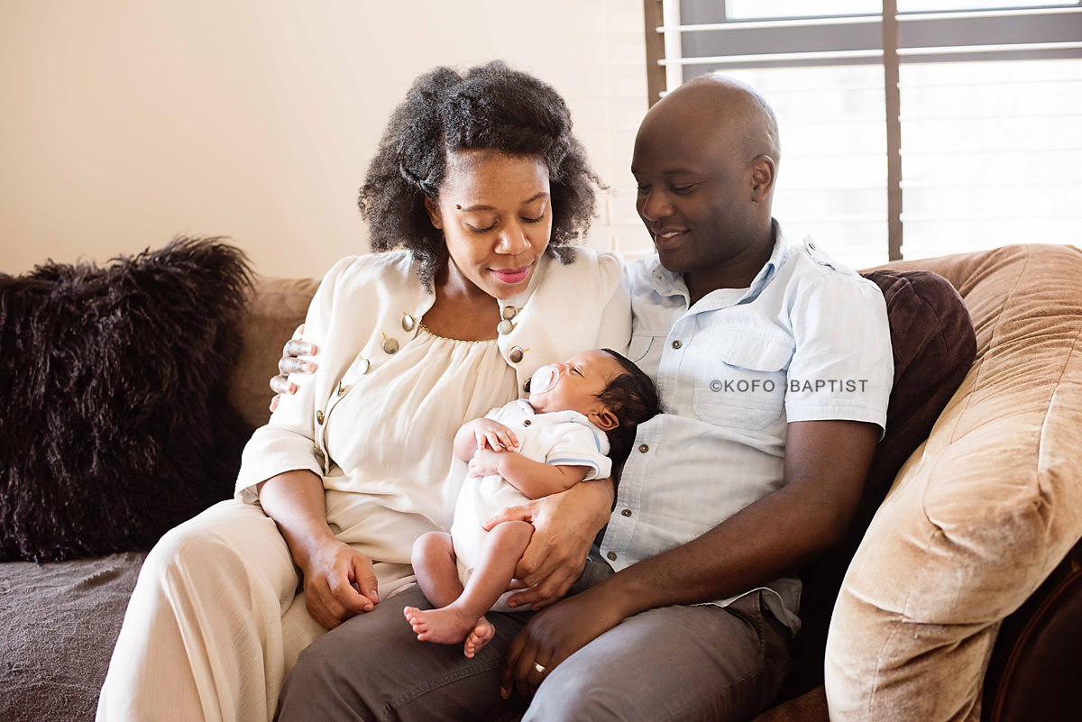 Mum and dad looking at newborn baby and smiling.
