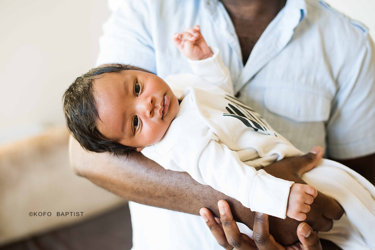 Dad holds newborn baby in his arms