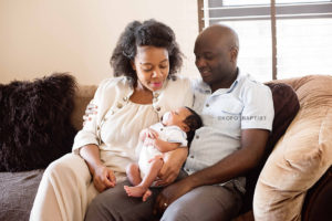 Mum and dad looking at newborn baby and smiling.
