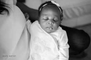 Mother holds newborn baby in her arms.