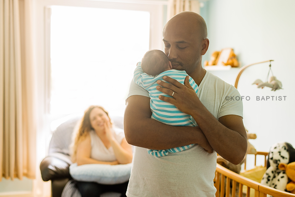 Daddy carrying newborn baby on his shoulder.