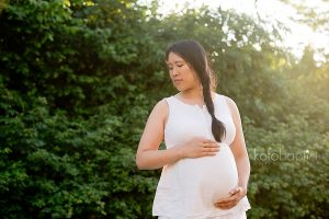 Pregnant woman with hands on baby bump