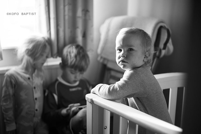 London child photographer photographs toddler in his cot.