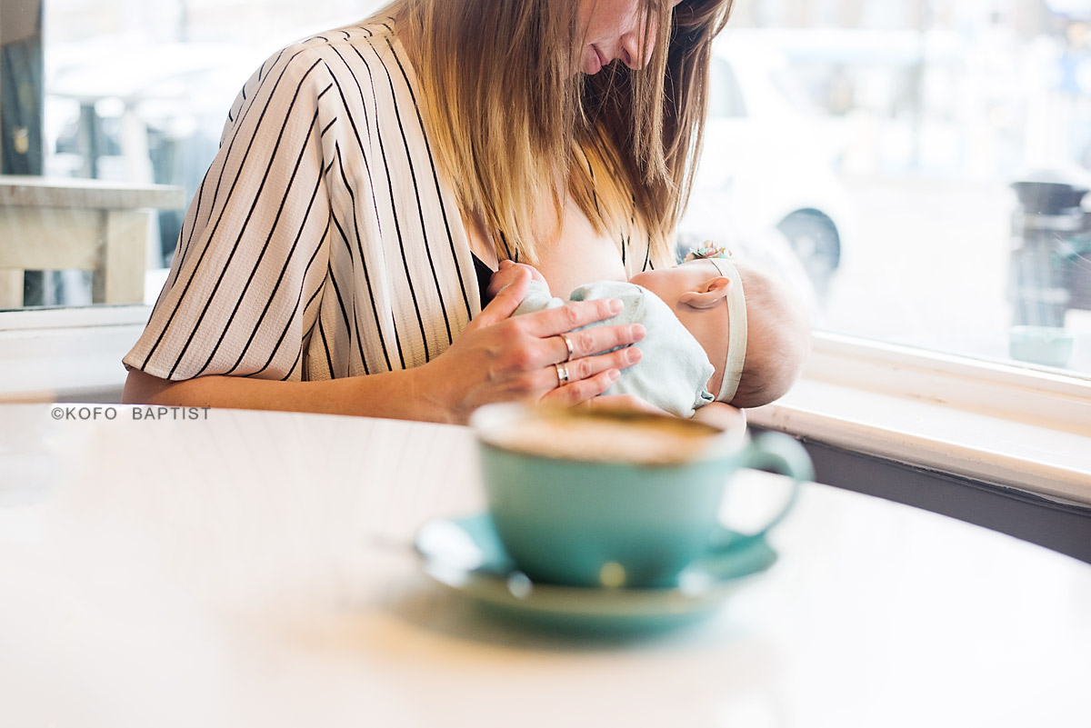 A mother breastfeeding her baby in a cafe